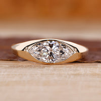 Flush diamond engagement ring with marquise diamond centre.
