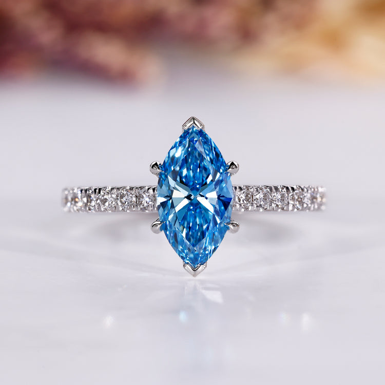 Marquise diamond engagement ring with blue sapphire accent.
