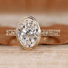 Oval cut diamond ring with bezel setting.
