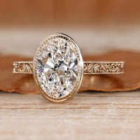 Oval cut diamond ring with bezel setting.