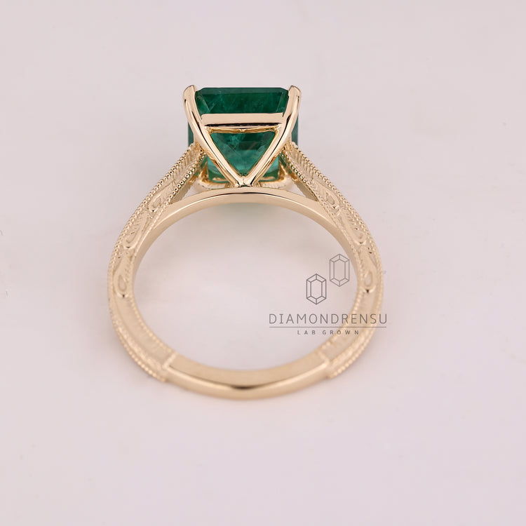 Emerald gemstone ring four claw prong cathedral set.
