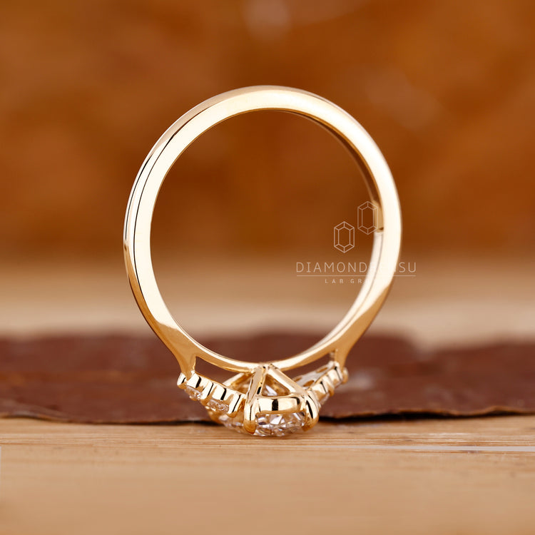 Oval diamond ring round side stones prong set.
