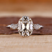 Cushion Old European Cut Ring with round side stones.
