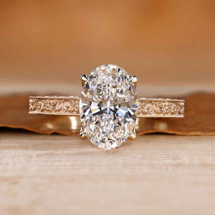 Oval cut diamond ring with round bridge accents.