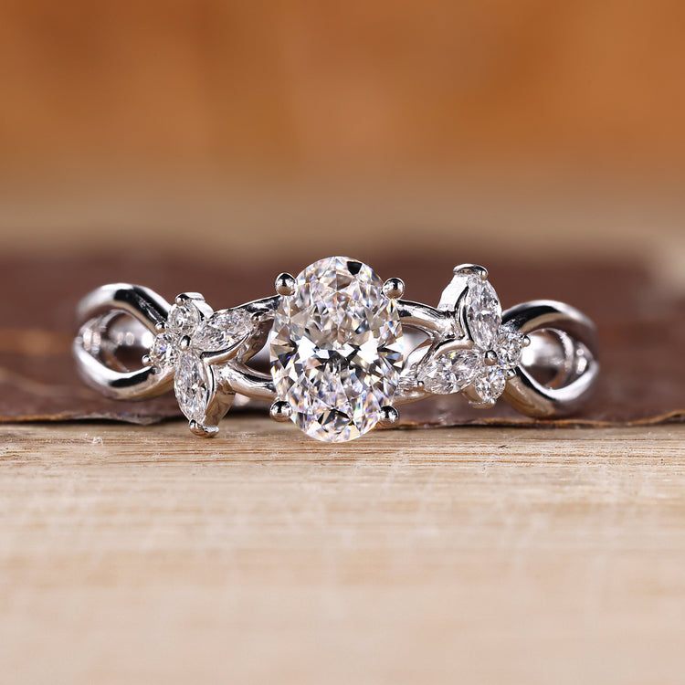 Oval diamond engagement ring with marquise and round side stones.
