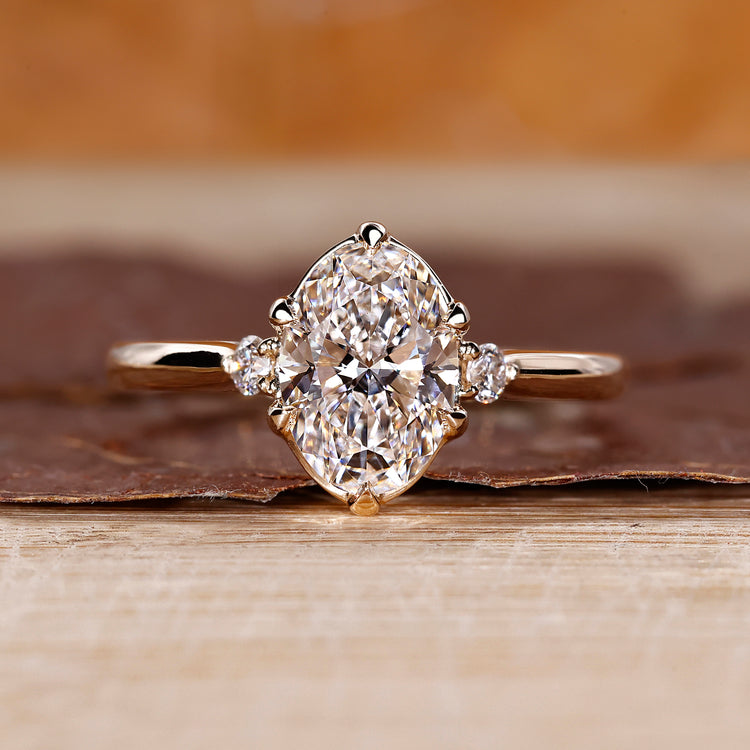 Oval cut diamond ring round side stones three stone.
