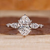 Oval cut diamond ring with pear and round side stones.
