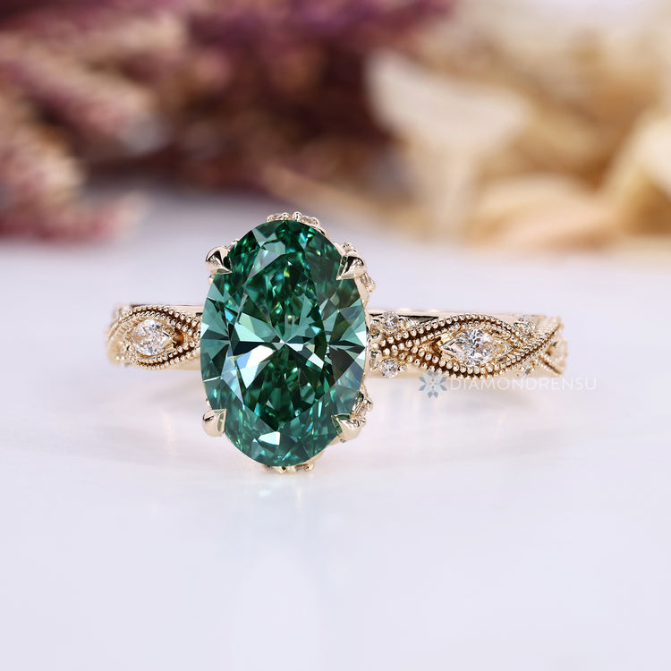 Green diamond ring with marquise and round side stones.