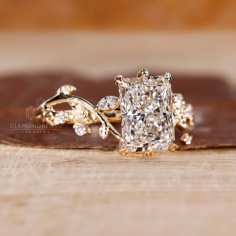 Radiant cut centre diamond ring with organic leaf setting.
