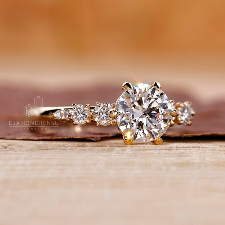 Round side stones used in yellow gold engagement ring.
