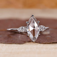 Marquise rose cut engagement ring with pear side stones.
