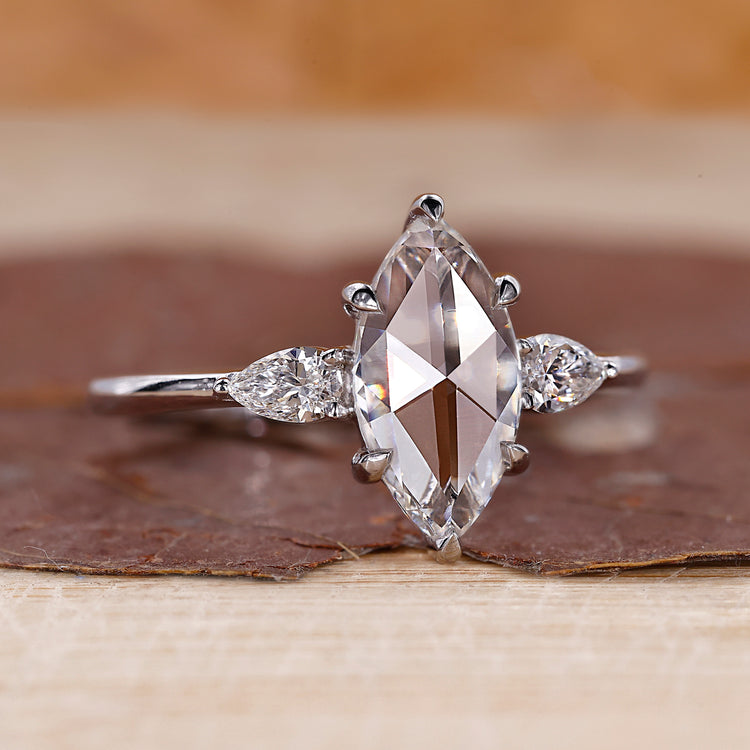 Marquise rose cut engagement ring with pear side stones.

