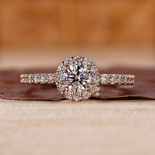 Round halo diamond ring in yellow gold with pave setting.

