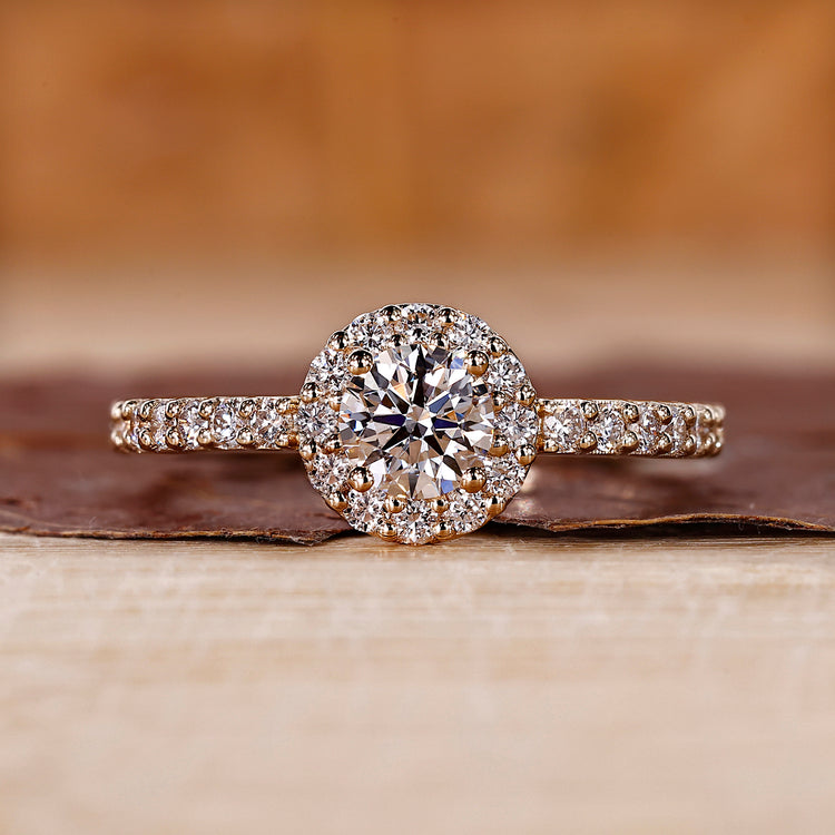 Round halo diamond ring in yellow gold with pave setting.
