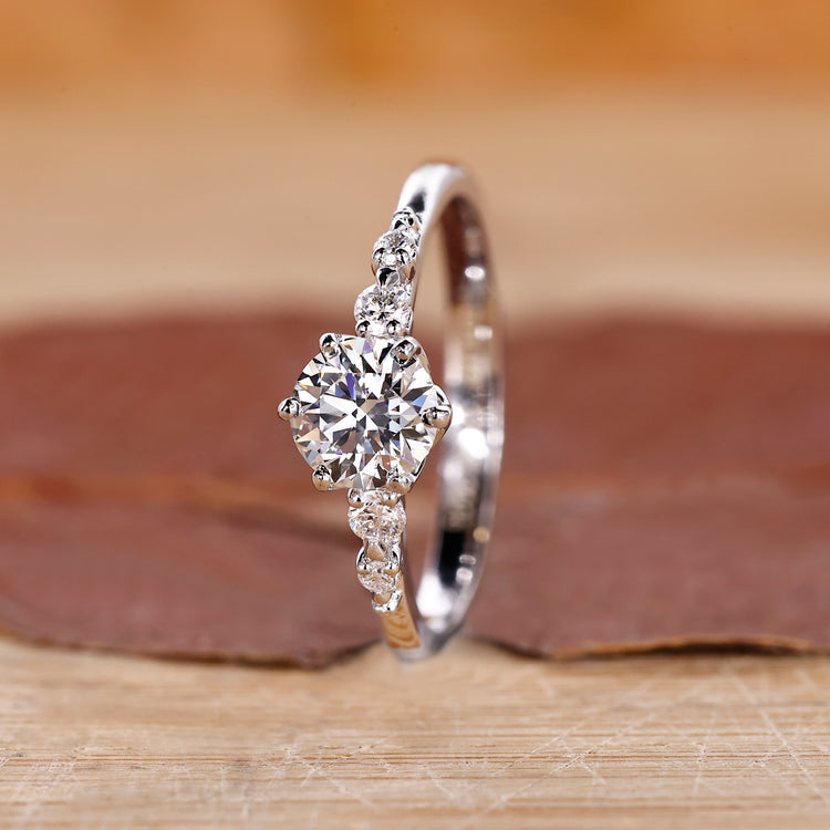 Round engagement ring with five diamonds in tapered shank design.
