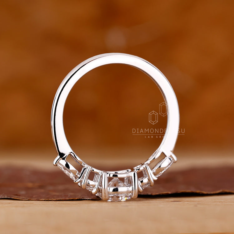 4 Claw Prong Ring holding marquise and round diamonds.
