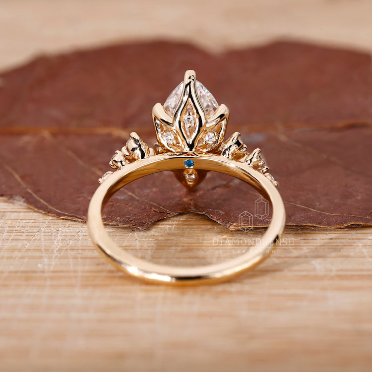 Yellow gold engagement ring with marquise center and round accents.
