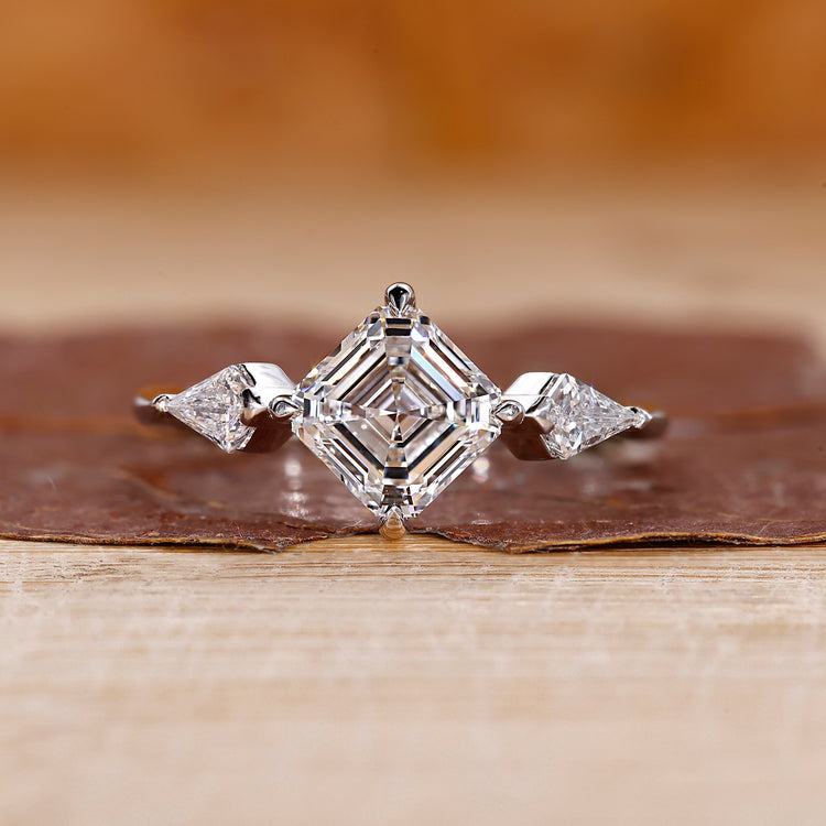 Asscher cut diamond ring with kite side stones.
