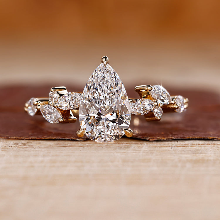 Pear diamond engagement ring with cluster engagement ring.
