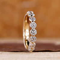 Round diamond wedding band in yellow gold.
