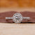 Pave diamond ring with round cut center stone.
