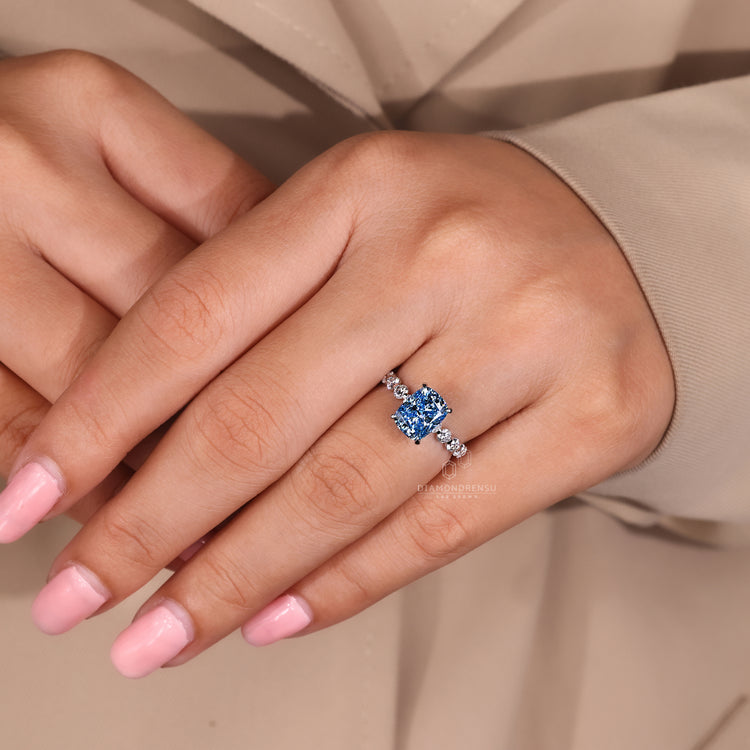 Lab grown diamond cushion cut ring with sapphire detail.
