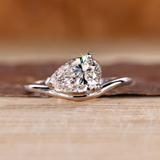 Pear diamond ring in solitaire style with east to west setting.
