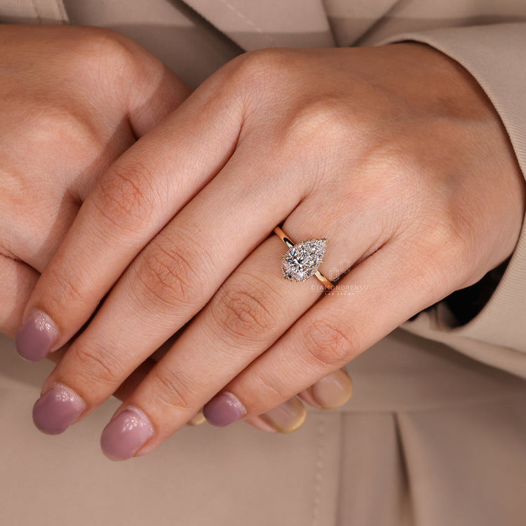 Pear cut diamond ring with round hidden halo style.
