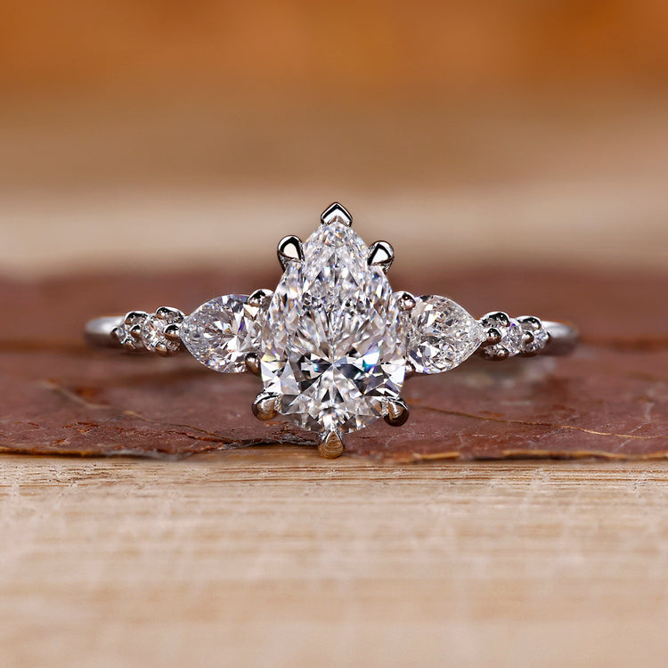 Pear cut diamond ring pear round side stones seven stone.
