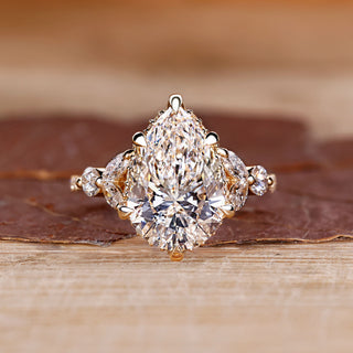 Pear cut diamond engagement ring with round and marquise side stones.
