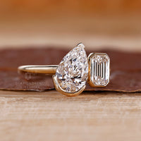 Pear emerald diamond ring two stone prong setting.
