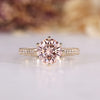 Round diamond ring with pink diamond accent.