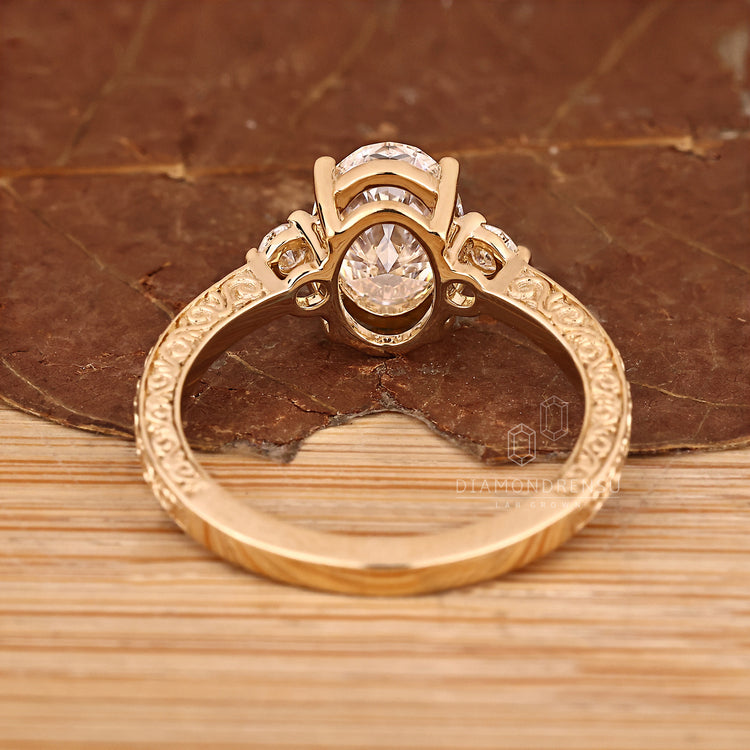 Oval diamond ring round side stones prong set.
