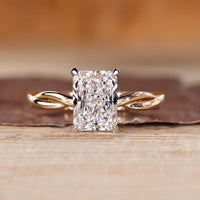 Radiant cut diamond ring with twisted shank in solitaire style.
