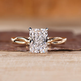 Radiant cut diamond ring with twisted shank in solitaire style.

