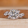 Round diamond ring with marquise and round side stones.