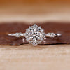 Round cut diamond ring halo cluster four prong setting.

