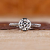 Bezel diamond ring with round centre diamond.
