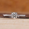 Round cut diamond ring pave tapered shank four prong.
