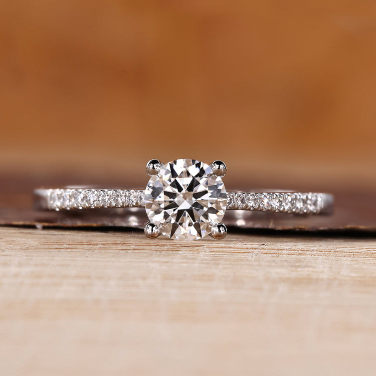 Round cut diamond ring pave tapered shank four prong.
