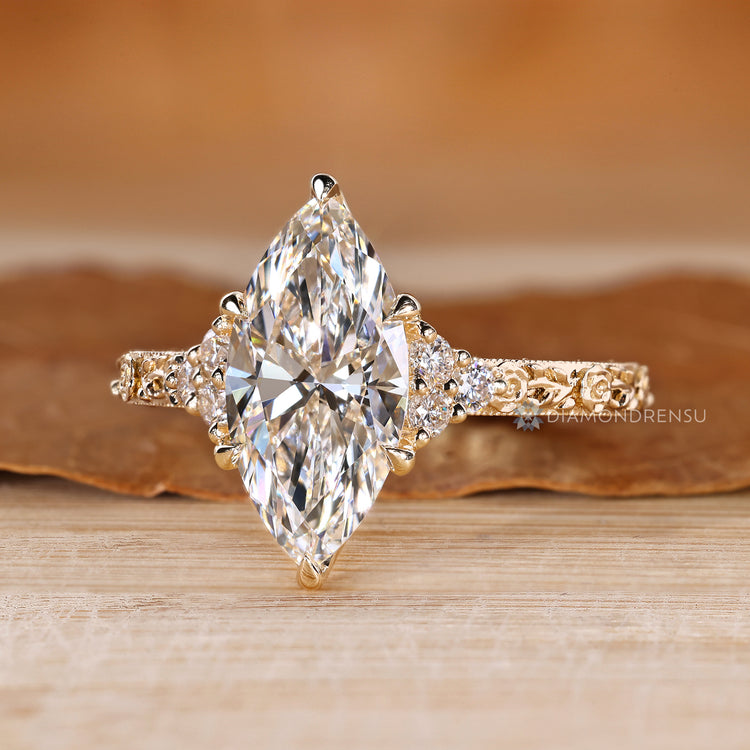 Marquise ring with milgrain detailing and round side stones.