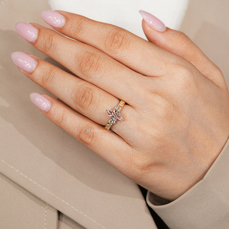 Marquise ring with round side stones and milgrain details.