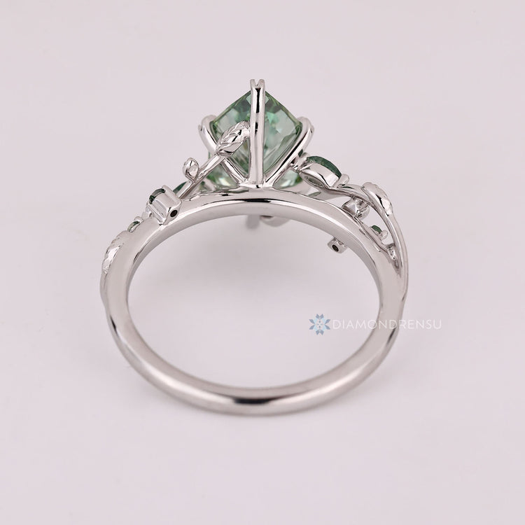 Green diamond engagement ring with round moss agate side stones.