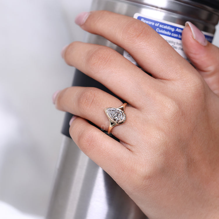 Pear cut ring solitaire bezel type prong setting.
