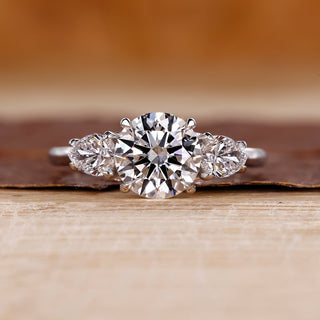 Round cut diamond ring pear side stones three stone.
