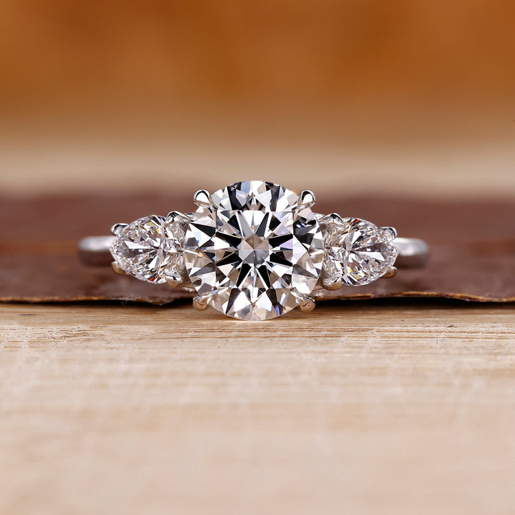 Round cut diamond ring pear side stones three stone.
