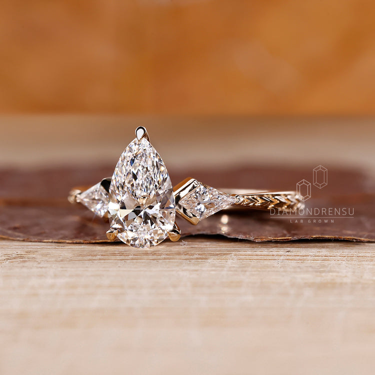 Art deco pear diamond ring kite side stones design.