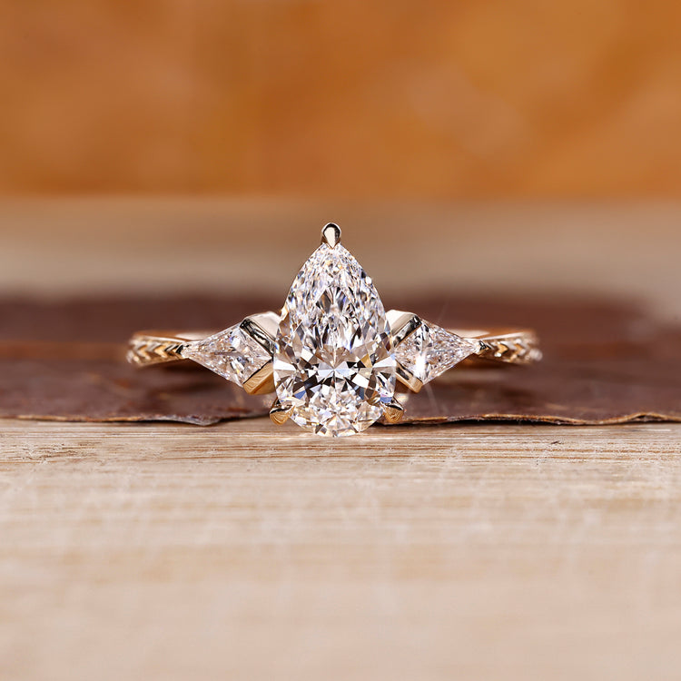 Pear cut diamond ring kite side stones art deco style.