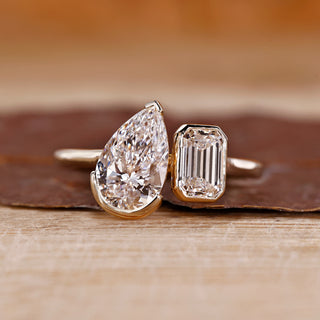 Toi et moi ring pear emerald diamond bezel prong set.
