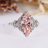 Pink diamond ring with trillion and round side stones.